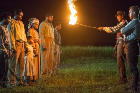 Cato-Alano-Miller-holding-a-fire-torch-confronting-some-of-the-Macon-7-slaves-800x533