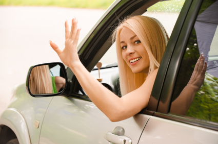 Driver-woman of car waves back as sign of farewell.