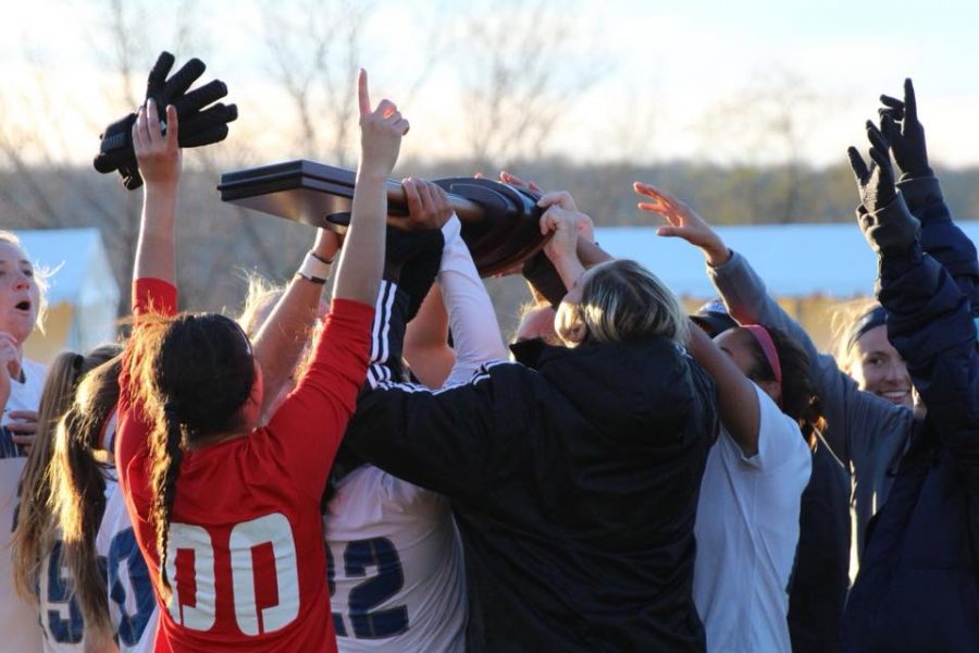 The Mercy Mavericks raise the Eastern Region Championship trophy in the air after a 2-0 win of LIU Post University. 