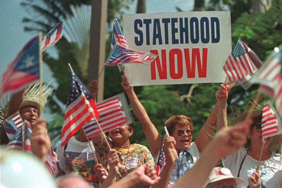 Supporters of Puerto Ricos pro-statehood movement cheer the arrival of Governor Pedro Rossello outside status hearings being held in San Juan, Puerto Rico Saturday April 19, 1997. If an Alaskan Republican gets his way, Puerto Rico will soon decide whether it wants to be independent of the United States, become a 51st state, or settle for the status quo. Theres only one problem, says U.S. Representative Don Young. The status quo - commonwealth - cant last forever. (AP Photo/John McConnico)